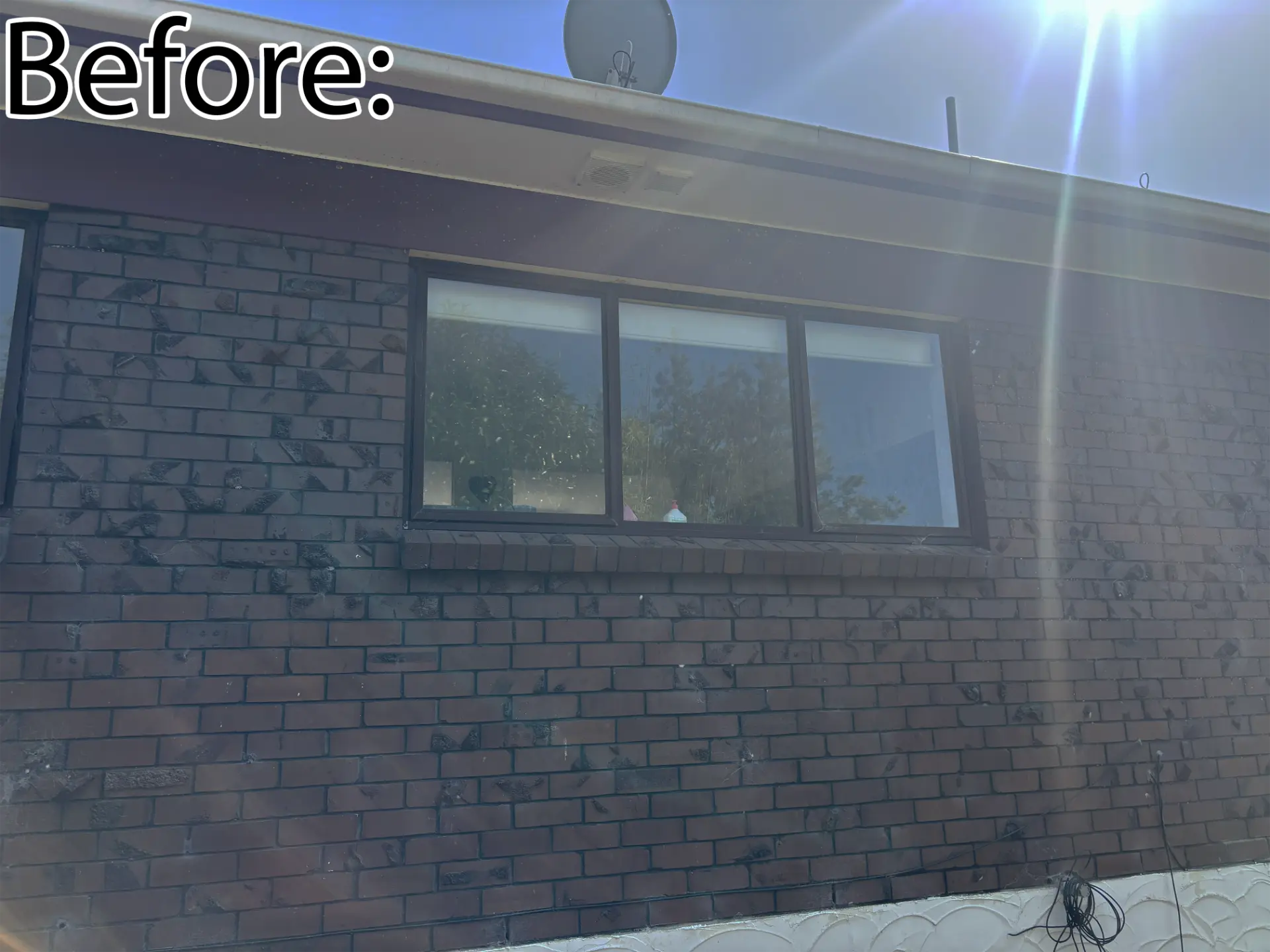 Selwyn Road side wall before: brown brick with dark aluminium slider window